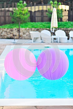 huge balloons of pink and purple colar float in the pool