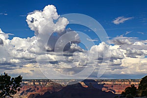 Huge billowing clouds in a blue sky above the Grand Canyon with dramatic shadows