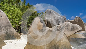 Huge bizarre granite boulders with smoothed slopes are piled on the sandy beach