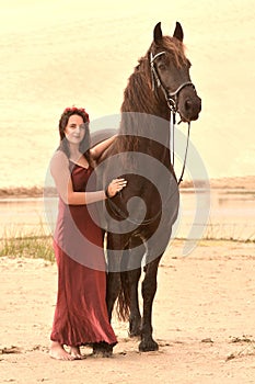 Huge black horse and pretty woman in red