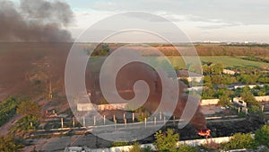 Huge black smoke from a fire in abandoned place with big red brick tube