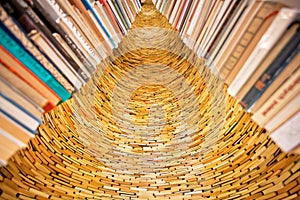 Huge bookworm tower built from old novels and volums of historical library. Big installation with many vintage books