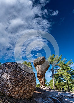 Huge boulder in balance with blurred unrecognizable tourists