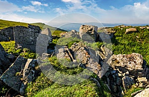 Huge boulders on a grassy hillside at sunrise