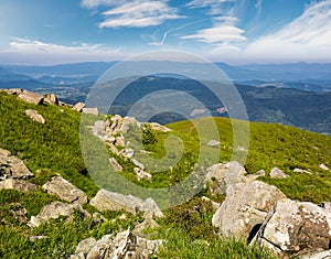 Huge boulders on a grassy slope in mountains