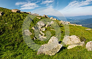 Huge boulders on a grassy slope in mountains