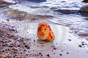 Huge bright yellow amber with sand on a beach