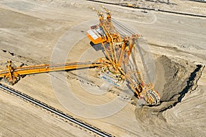 Huge bucket wheel excavator or mobile strip mining machine mining coal in a quarry. Heavy industry concept