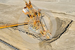 Huge bucket wheel excavator or mobile strip mining machine mining coal in a quarry. Heavy industry concept