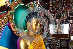 Huge buddha golden statue decorated with religious flags and offerings at evening