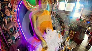 Huge buddha golden statue decorated with religious flags and offerings at evening