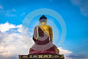 Huge buddha golden statue from different perspective with bright blue sky at evening