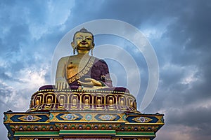 Huge buddha golden statue from different perspective with moody sky at evening