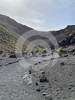 A huge caldera of an extinct volcano covered with black volcanic sand of Lanzarote Island
