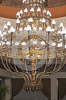 Huge chandelier in the hall. Chandelier on decoarted ceiling of a ballroom. vertical photo