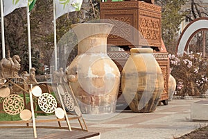 Huge clay jugs against the backdrop of giant Asian chests with carved ornaments - - street decor