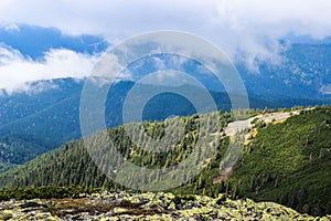 A huge cloud envelops the green Carpathian mountains