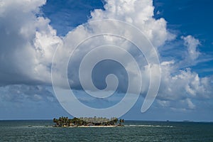 Huge clouds over small island in Caribbean Sea photo