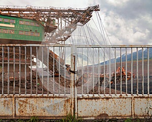 Huge coal mining coal machine behind an iron gate