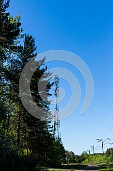 Huge communication antenna tower and satellite dishes against blue sky.Telecommunications tower cells for mobile