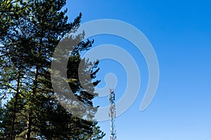 Huge communication antenna tower and satellite dishes against blue sky.Telecommunications tower cells for mobile