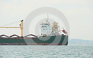 Huge container tanker ship carrying truck size colourful containers in deep blue open ocean sea