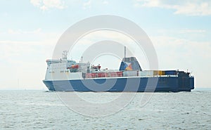 Huge container tanker ship carrying truck size colourful containers in deep blue open ocean sea