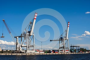 Huge crane for loading containers in the cargo terminal of sea port. Summers clear day. Blue sky. Copy space