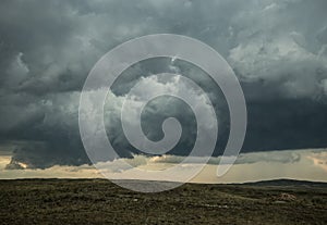 A huge cumulonimbus storm cloud over the steppe expanses.