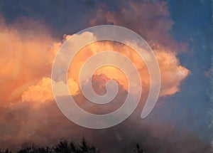 A huge cumulus cloud in the rays of the setting sun