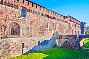 The huge defensive walls and deep dug moat of Sforza`s Castle in Milan, Italy