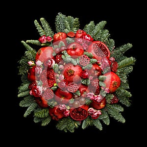 Huge edible fruit bouquet consisting of pomegranates, apples, grapes, rose flowers and fir twigs on black background