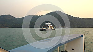 A huge ferry with people departs from the island.