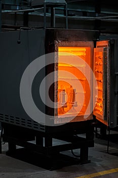 A huge furnace for heating steel. Dangerous technologies and occupations. A roasting oven on an industrial background.