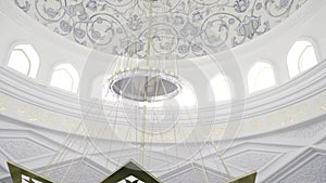 A huge glass chandelier.Scene.A white building with a painted ceiling on which hangs a huge fashionable chandelier made