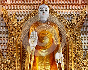 Huge gold statue of standing Buddha in buddhist temple