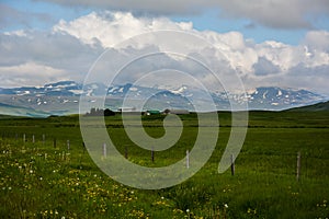 Huge green empty field with view to mountain and houses