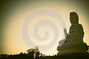 The huge Guan yin statue on the peak hill in silhouette sunset. Famous Chinese Buddha statue.