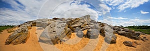 Huge heap of stones among a sandy desert at the hot summer day