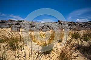 Huge heap of stones among a sandy desert at the hot summer day