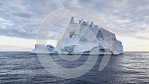 A huge high breakaway glacier drifts in the southern ocean off the coast of Antarctica at sunset, the Antarctic