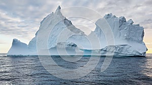 A huge high breakaway glacier drifts in the southern ocean off the coast of Antarctica at sunset, the Antarctic