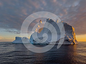 A huge high breakaway glacier drifts in the southern ocean off the coast of Antarctica at sunset, the Antarctic