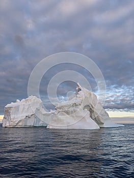 A huge high breakaway glacier drifts in the southern ocean off the coast of Antarctica at sunset, the Antarctic