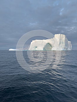 A huge high breakaway glacier drifts in the southern ocean off the coast of Antarctica at sunset, the Antarctic