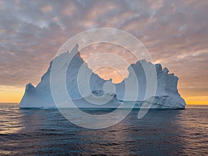 A huge high breakaway glacier drifts in the southern ocean off the coast of Antarctica at sunset, the Antarctic