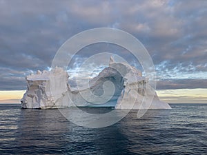 A huge high breakaway glacier drifts in the southern ocean off the coast of Antarctica at sunset, the Antarctic