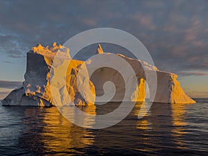 A huge high breakaway glacier drifts in the southern ocean off the coast of Antarctica at sunset, the Antarctic