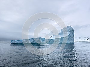 A huge high breakaway glacier drifts in the southern ocean off the coast of Antarctica at sunset, the Antarctic