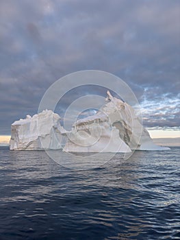 A huge high breakaway glacier drifts in the southern ocean off the coast of Antarctica at sunset, the Antarctic